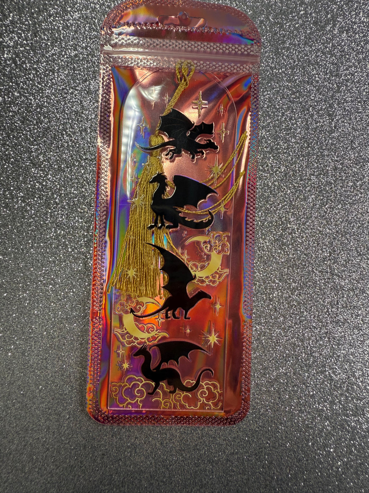 Iridescent packaging with a clear acrylic bookmark with dragon design