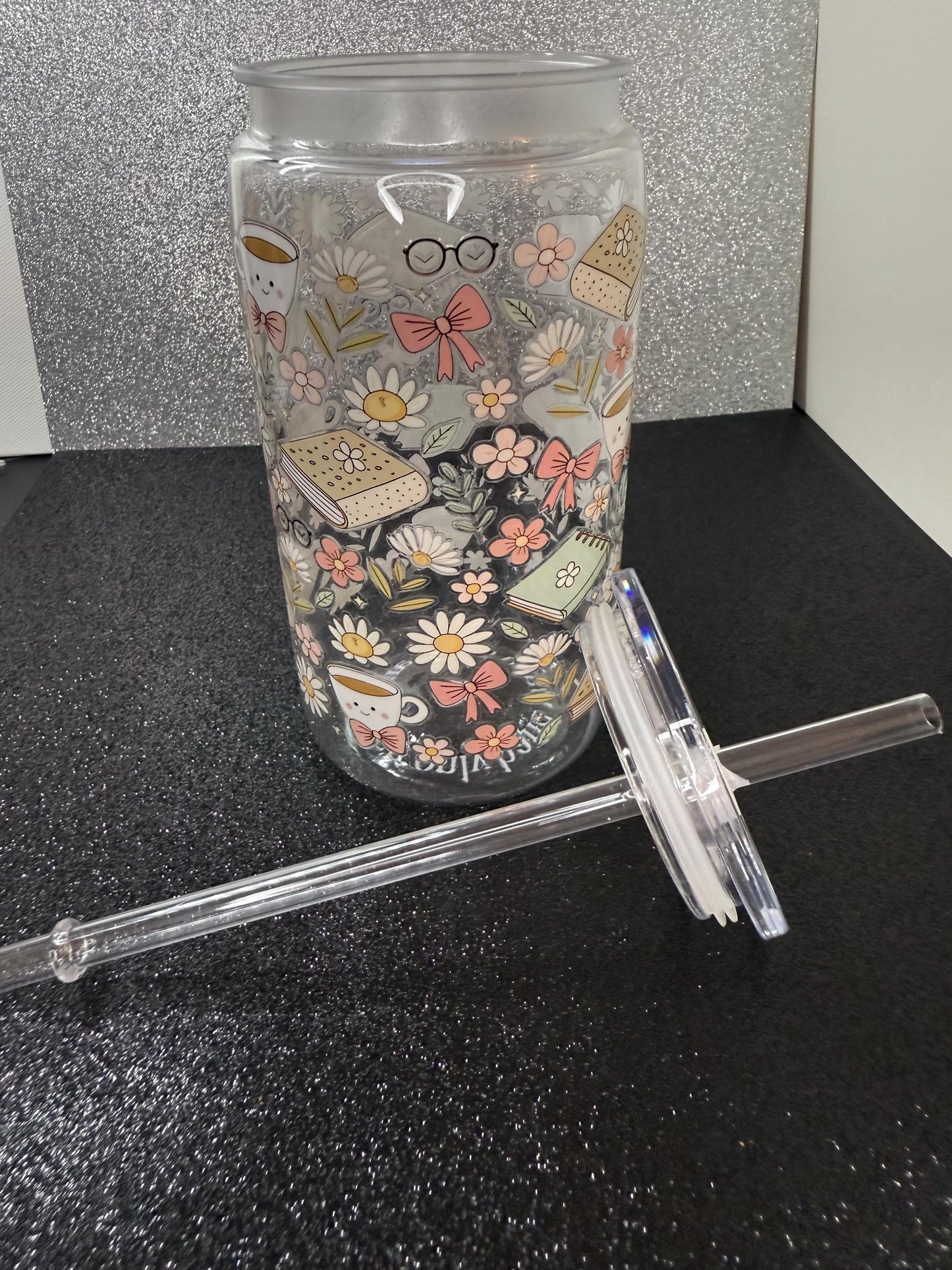 Tumbler with decorative design and straw on a black surface