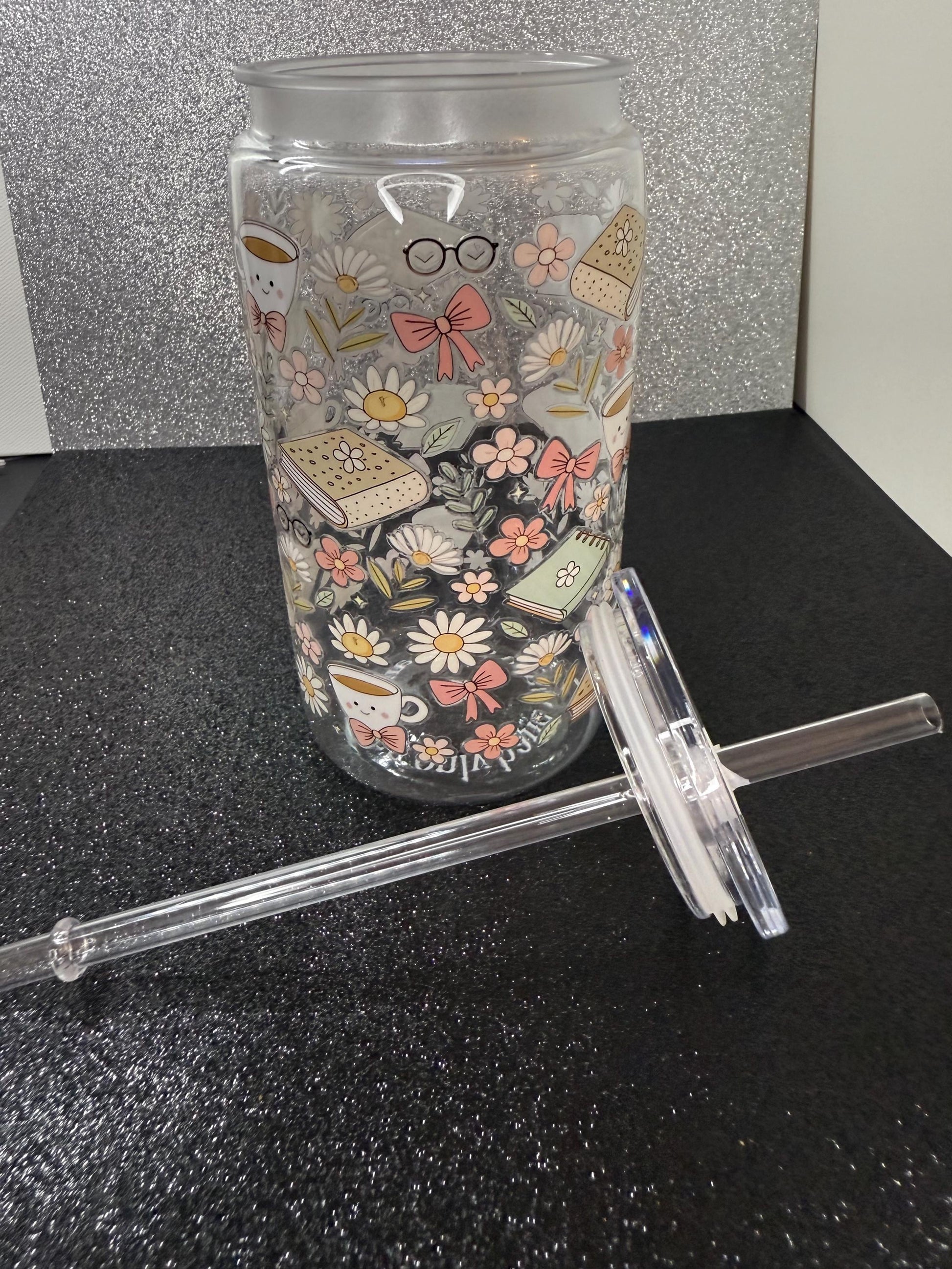 Tumbler with decorative design and straw on a black surface