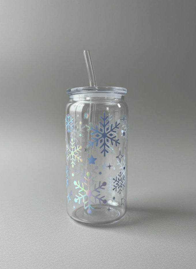 Clear tumbler with snowflake designs on a stone surface with a brick wall background