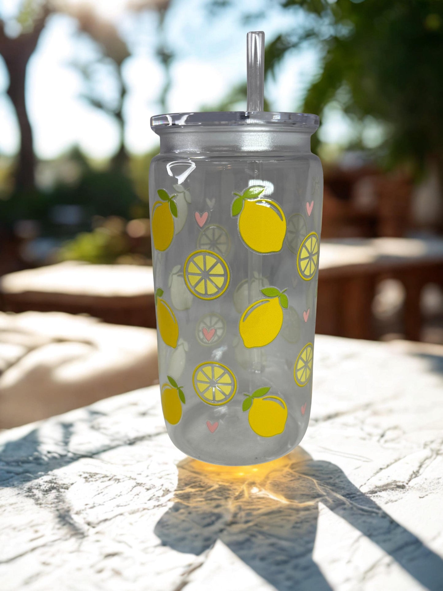 Clear tumbler with lemon pattern on a table outdoors