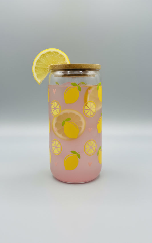 Clear tumbler with pink juice and lemon patterns on a textured surface