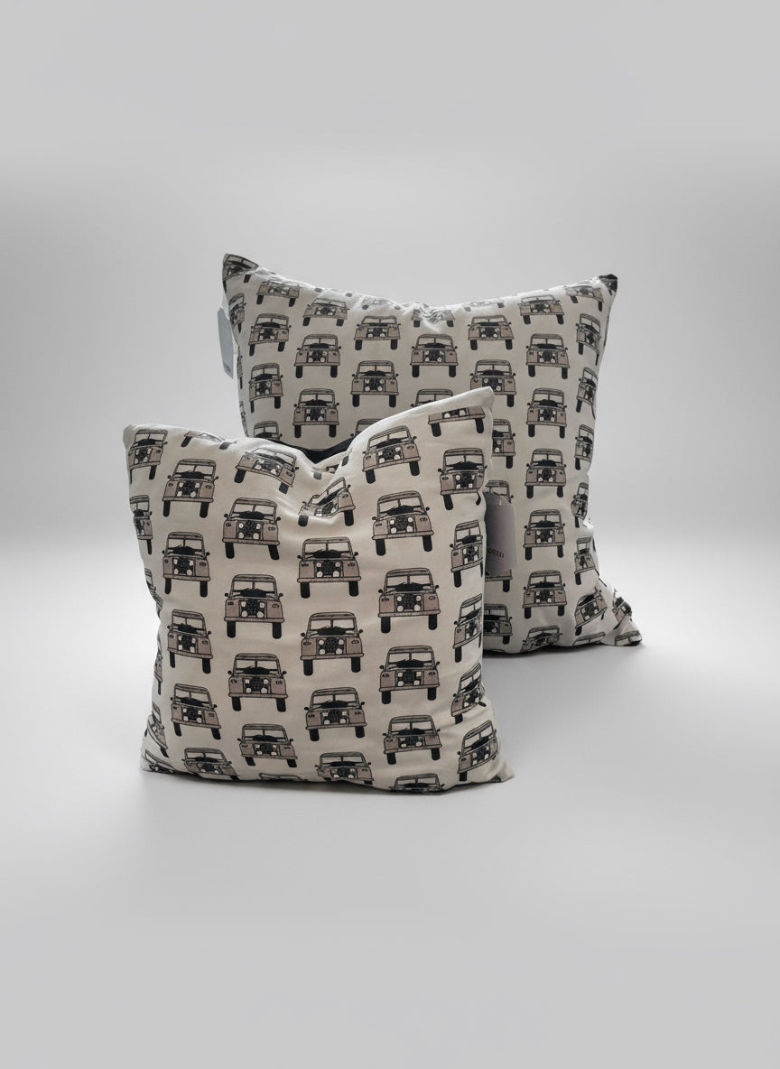Two patterned cushions with vehicle design on a white background