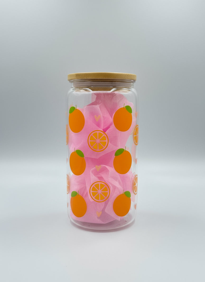 Clear glass with pink fabric and orange pattern on a gray surface