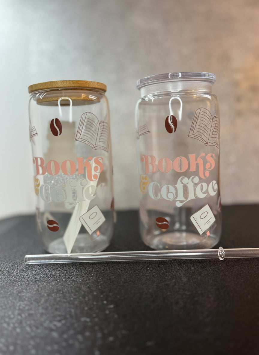 Two glass tumblers with 'Books & Coffee' text and coffee bean designs on a dark surface.