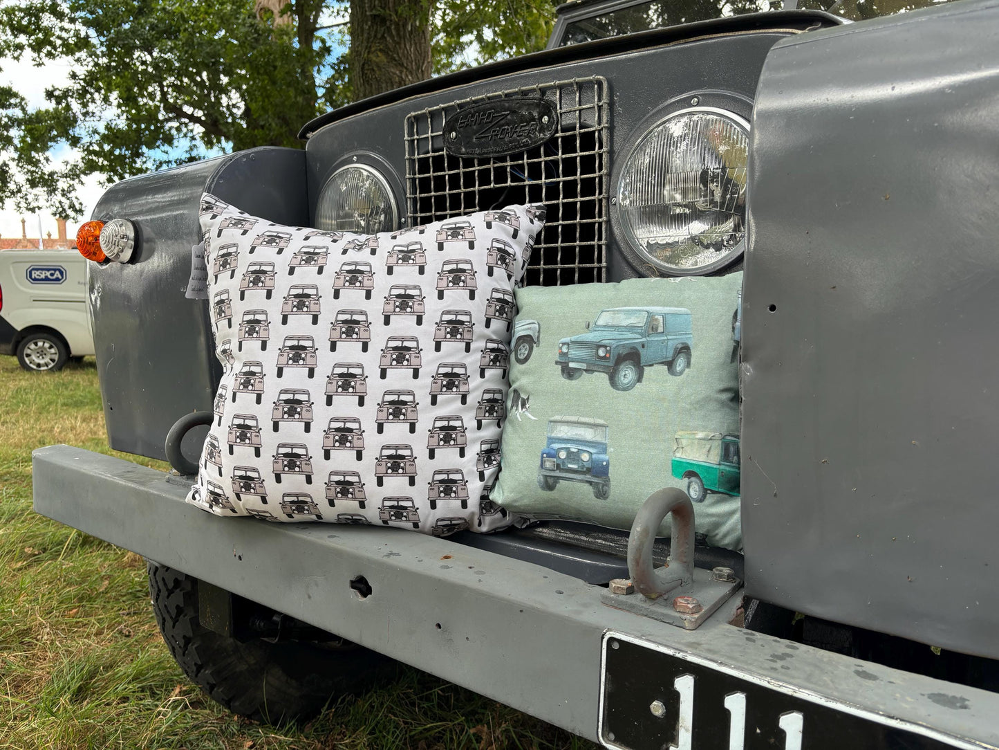 Two patterned cushions on the front of a Land Rover vehicle.