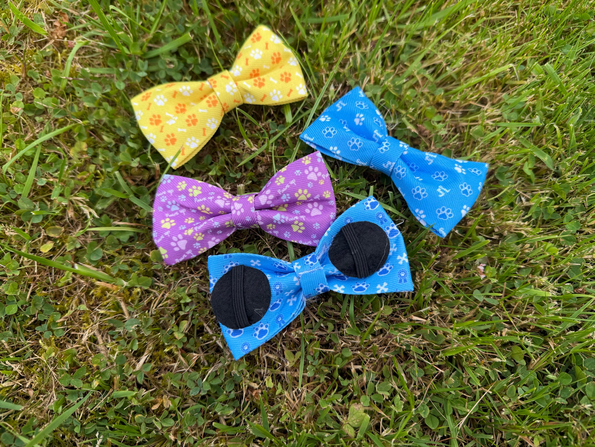 Four colorful bow ties on a grassy background