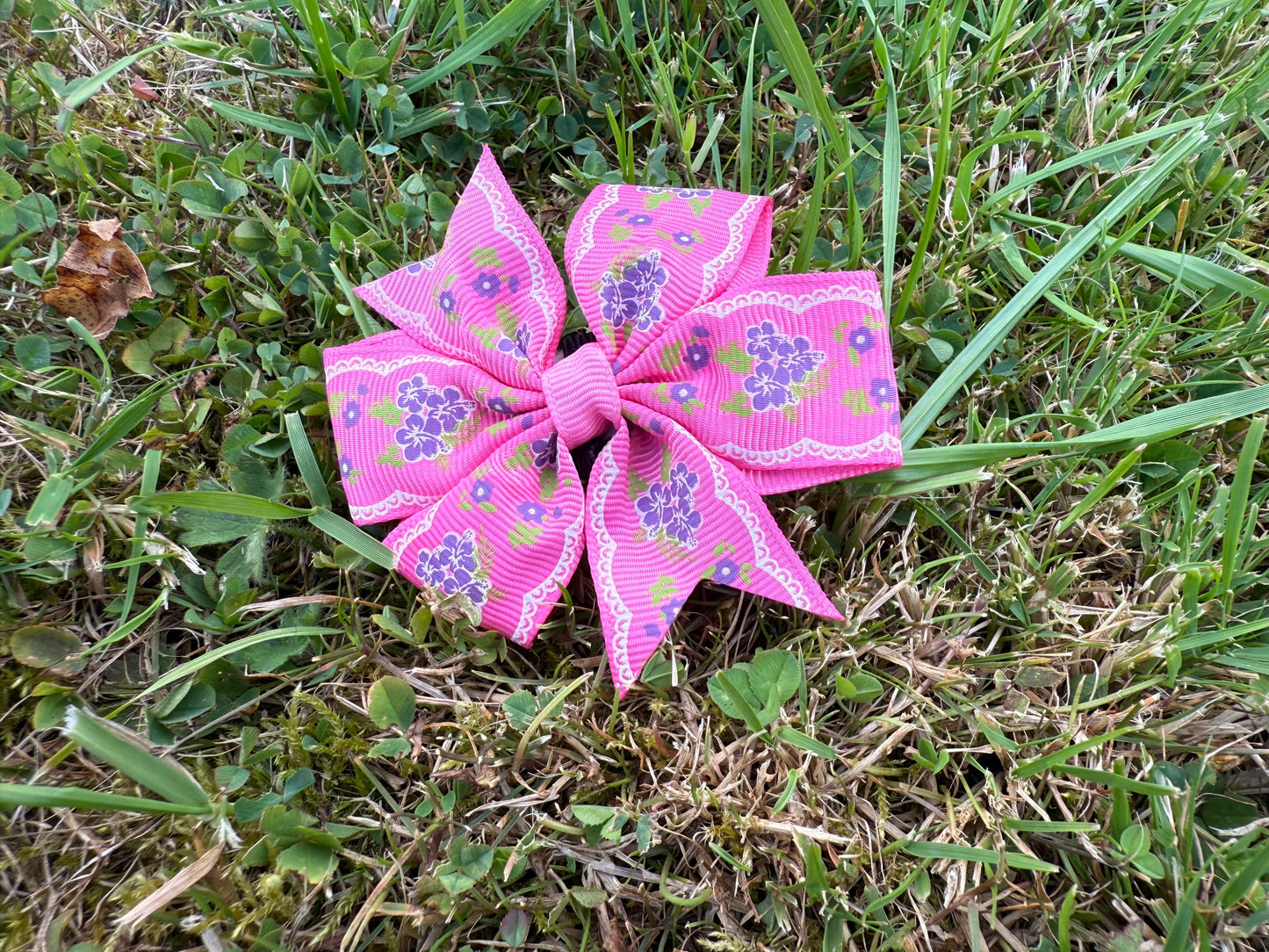 Pink floral bow on grass