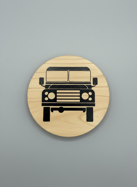 Wooden coaster with a laser-cut Land Rover design on a gray background