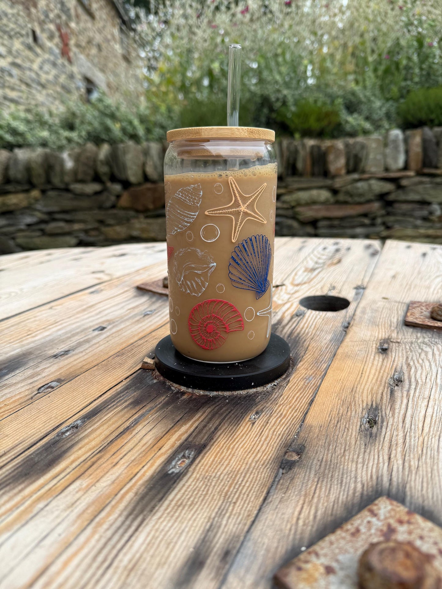 Glass with a straw on a wooden surface outdoors
