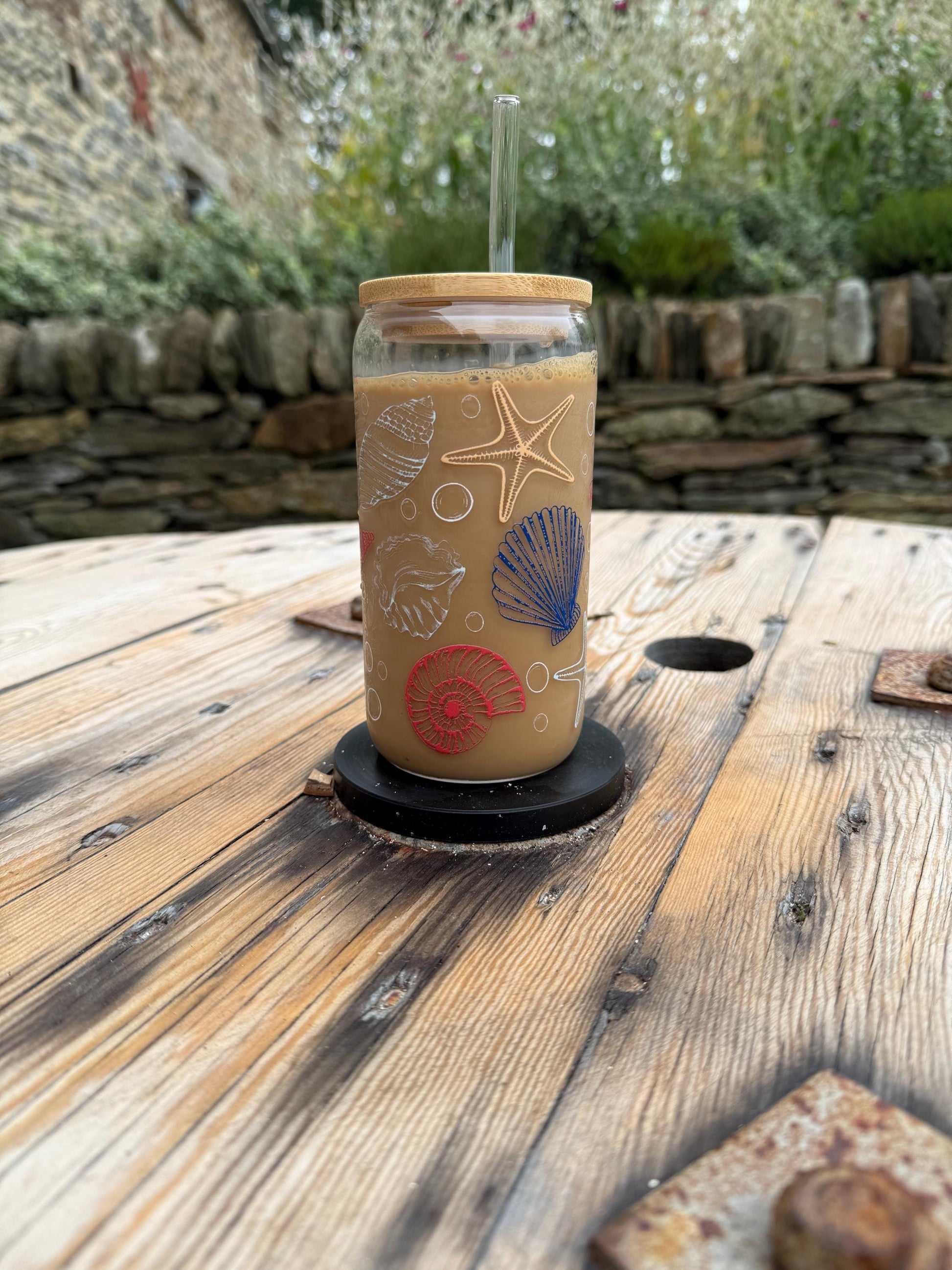 Glass with a straw on a wooden surface outdoors