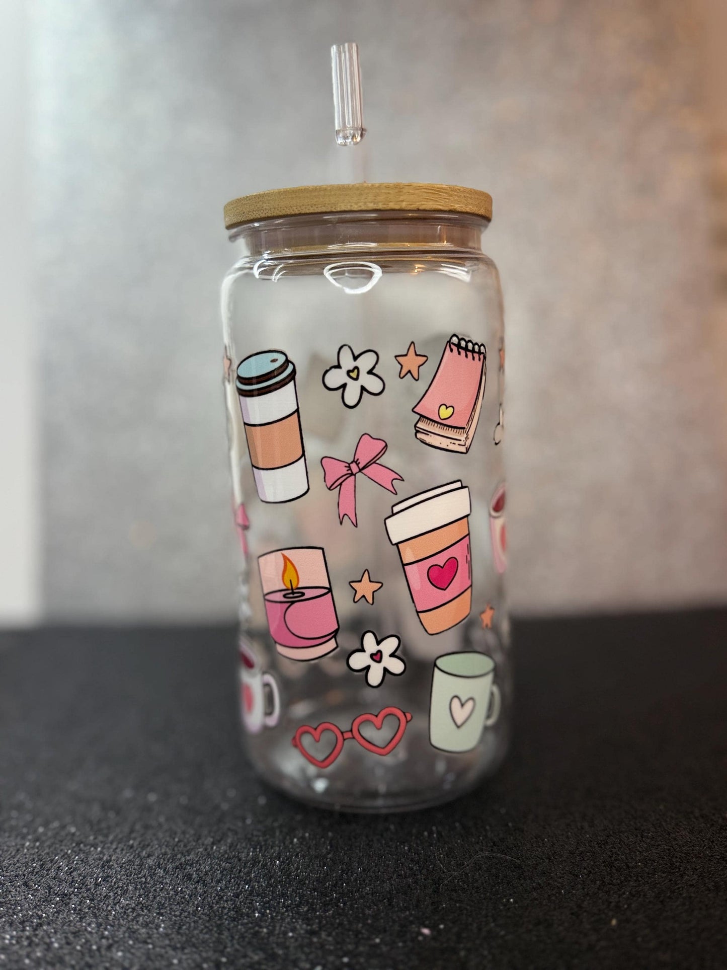 Clear tumbler with colorful designs on a black surface