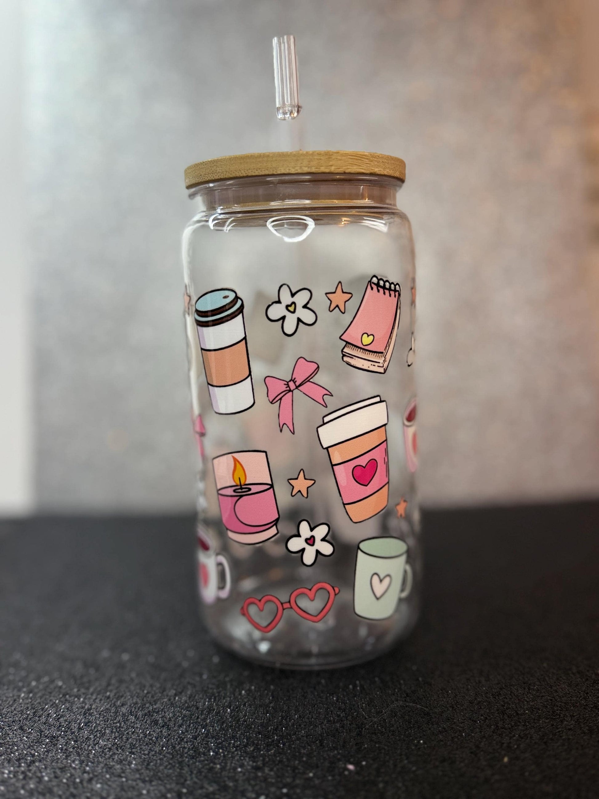 Clear tumbler with colorful designs on a black surface