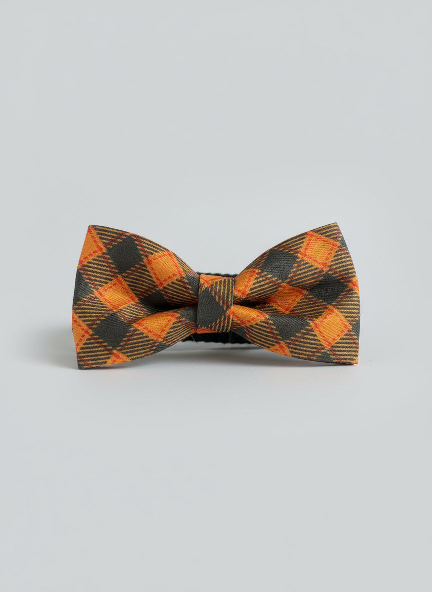 Checkered bow tie on a wooden surface with a brick wall background