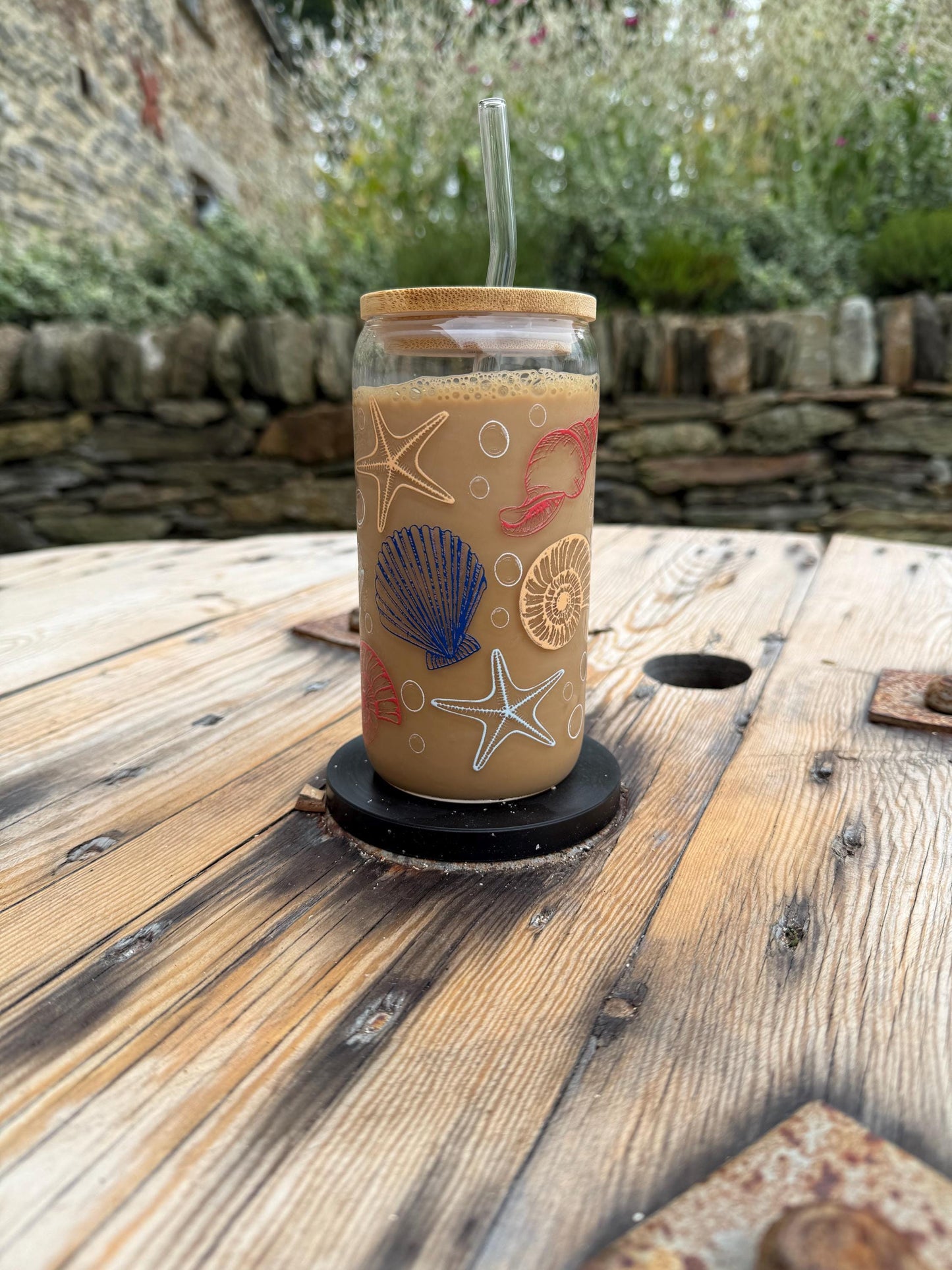 Glass with a straw on a wooden surface outdoors