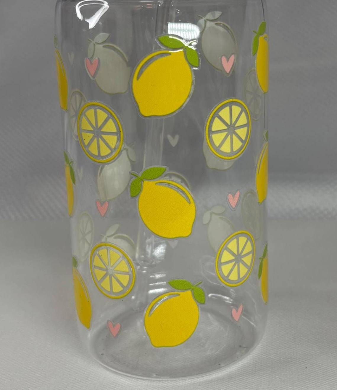 Clear glass tumbler with lemon pattern on a gray background
